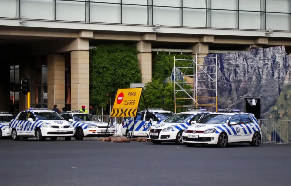 Police cars parked next to a closed road near the CTICC.